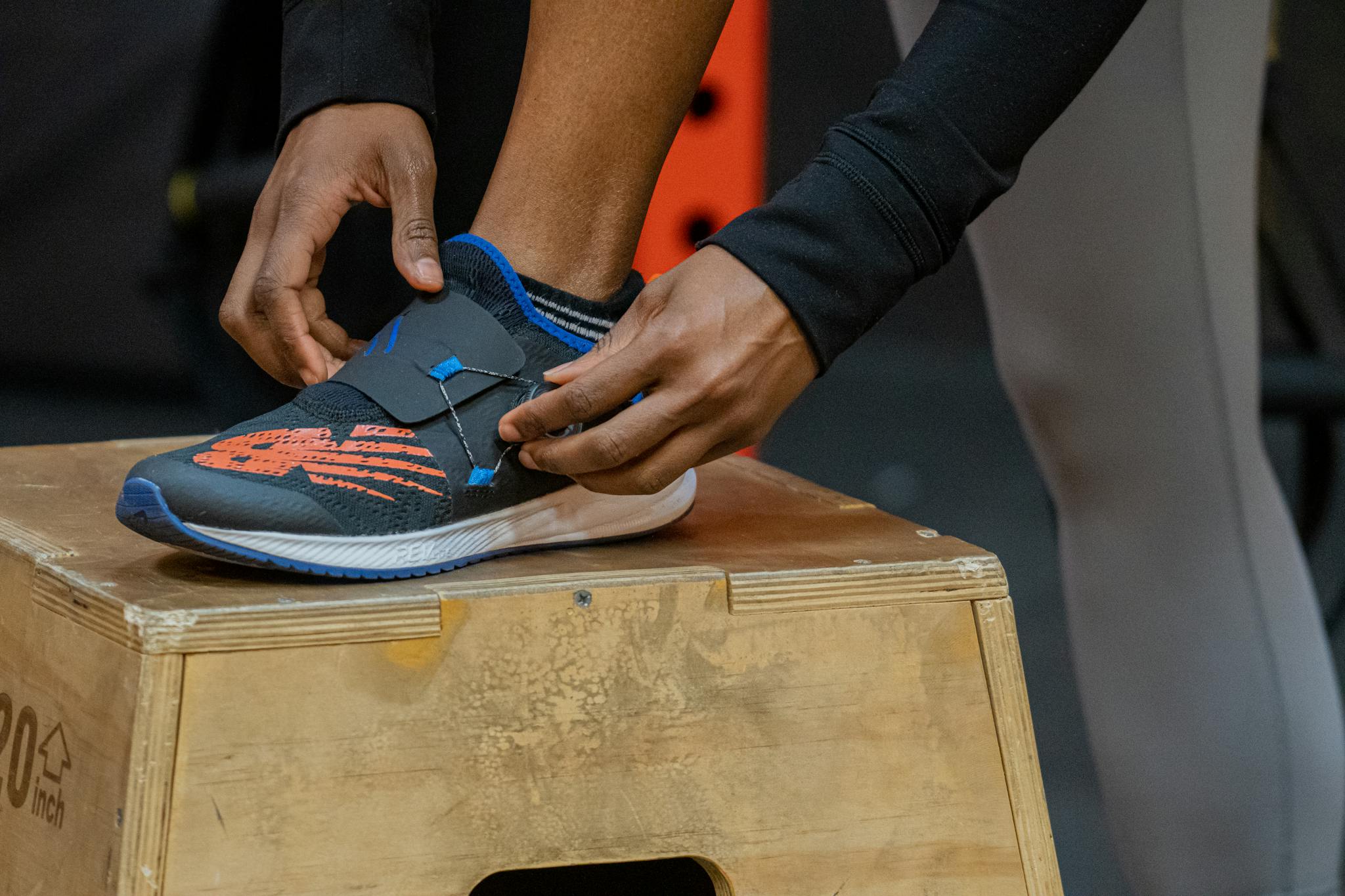 Close-up of a person fastening a sports shoe during a workout session, showcasing determination and athleticism.